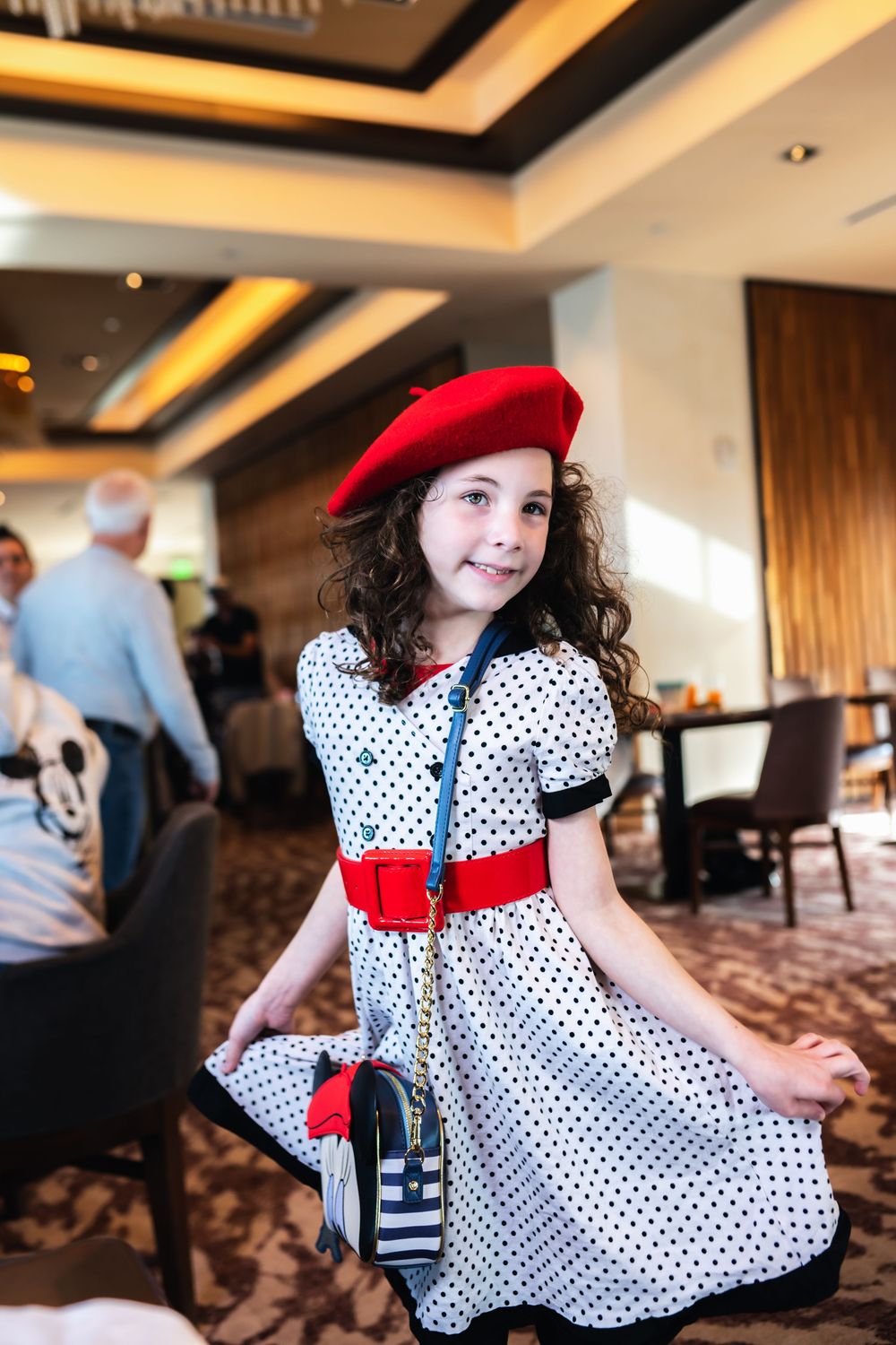 A polka dot dress with red accents twirls in a ballroom setting.