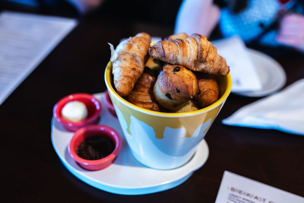 Chocolate truffles and pastries arranged on small plates and bowls on a dark wooden table.