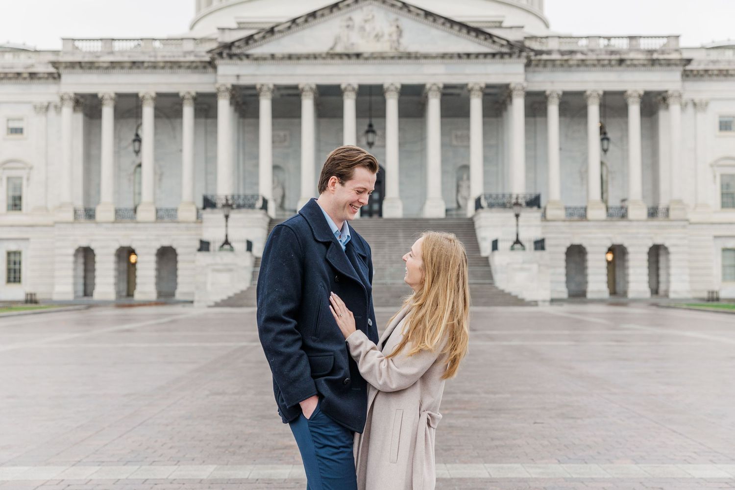 A couple shares a romantic moment in front of the United States Capitol building in Washington DC.