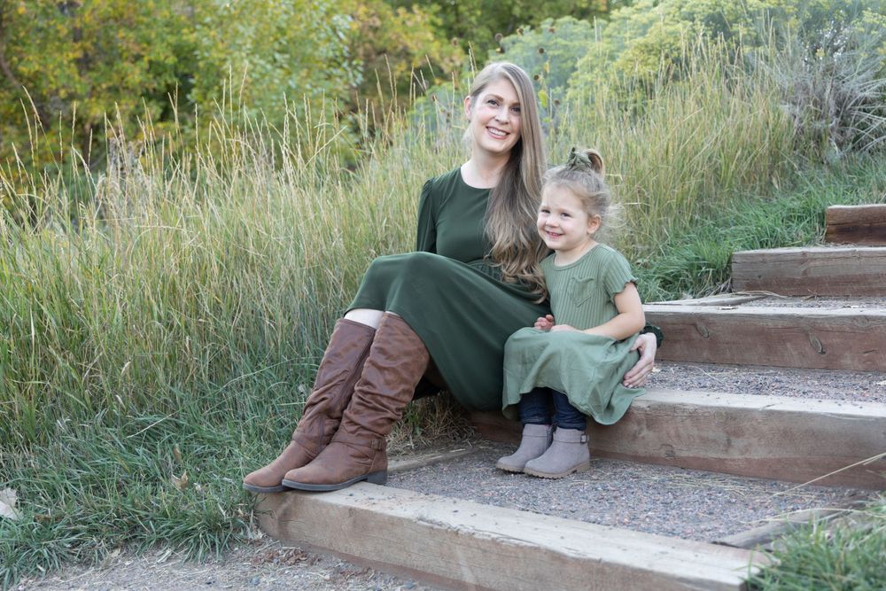 Two people sit together on stone steps surrounded by natural landscaping.