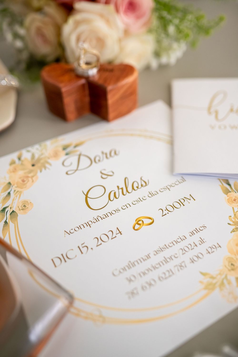 Close-up of elegant wedding invitation with gold floral details and December 2021 date.