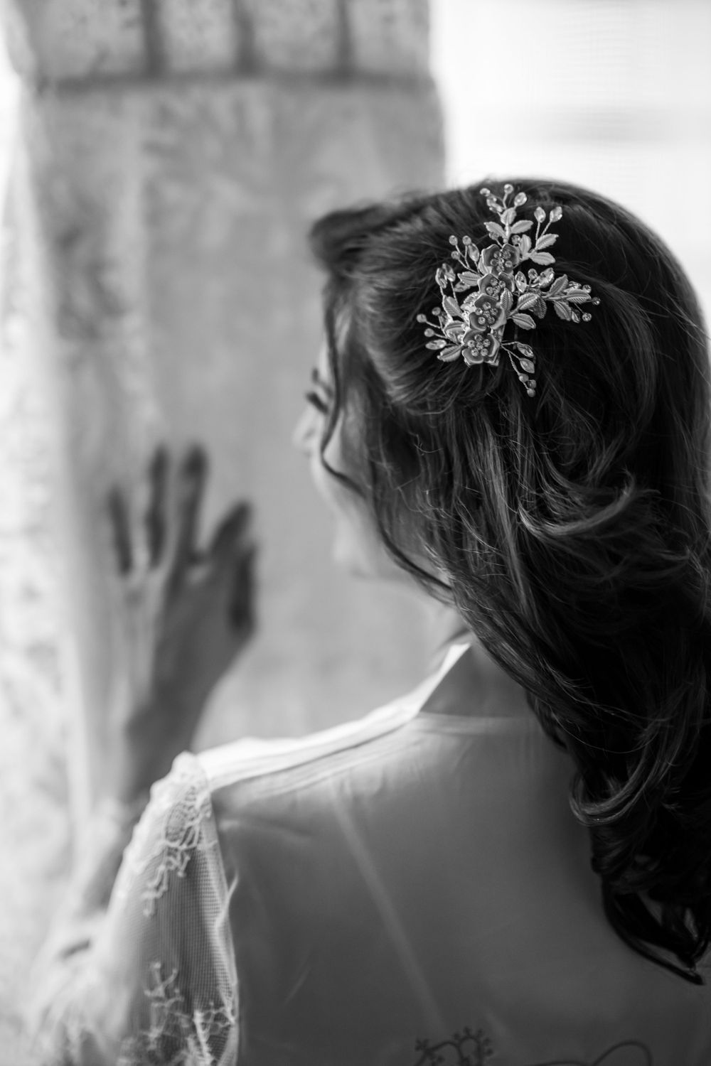 Silhouette of bridal hair accessories and veil against soft window light.