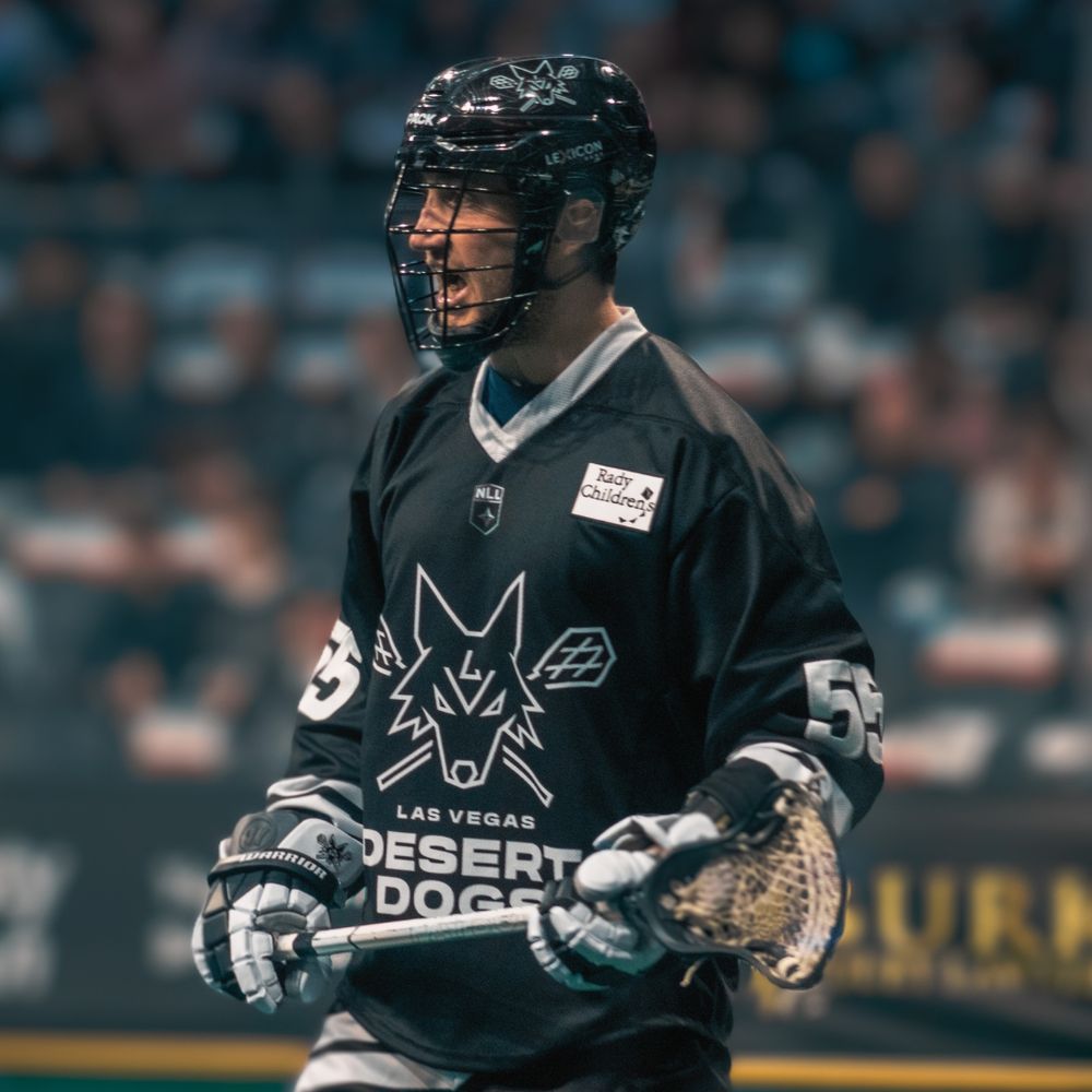 Las Vegas Desert Dogs lacrosse player number 53 stands on the field holding a stick during a game.