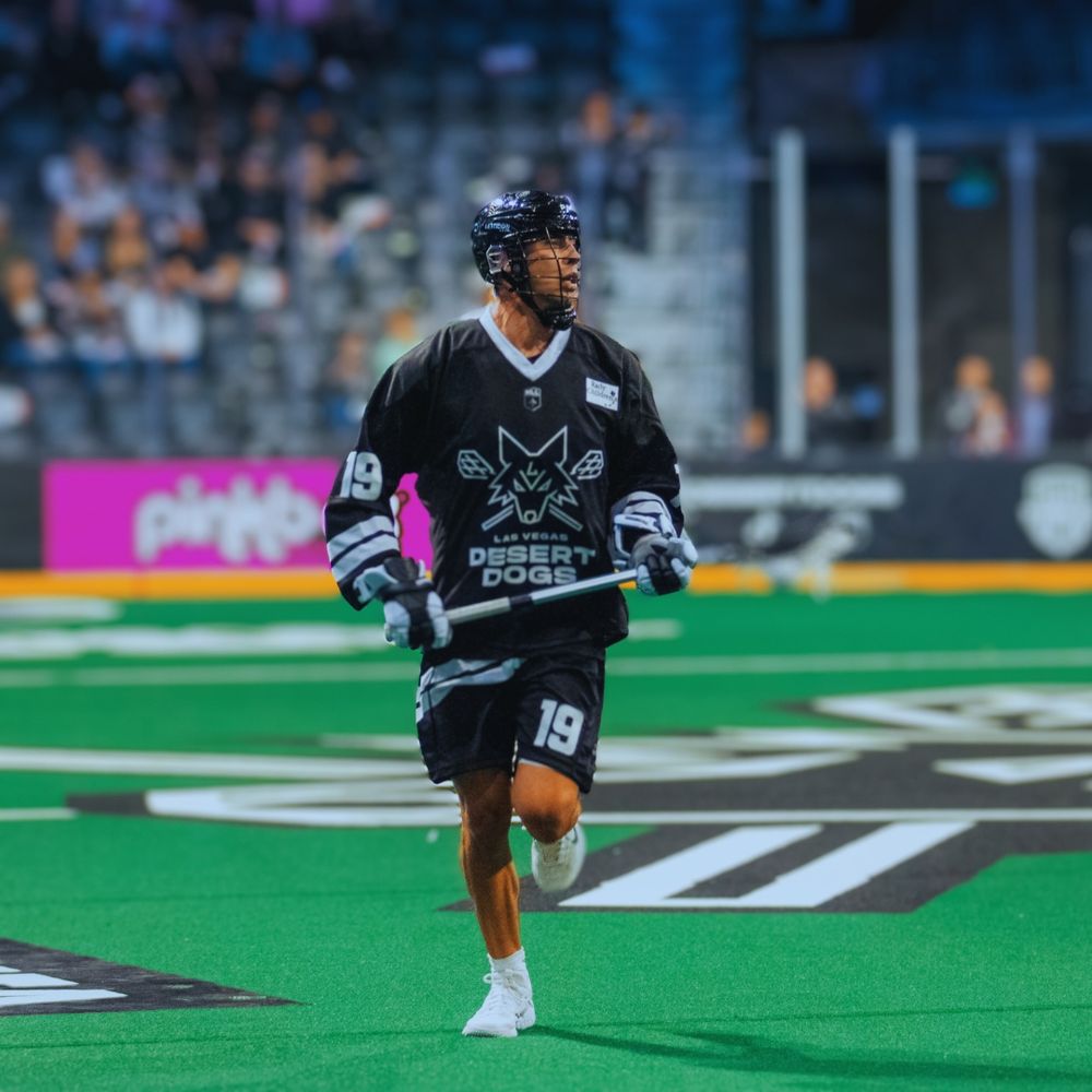 Las Vegas Desert Dogs player number 19 runs across the turf during a professional lacrosse game.