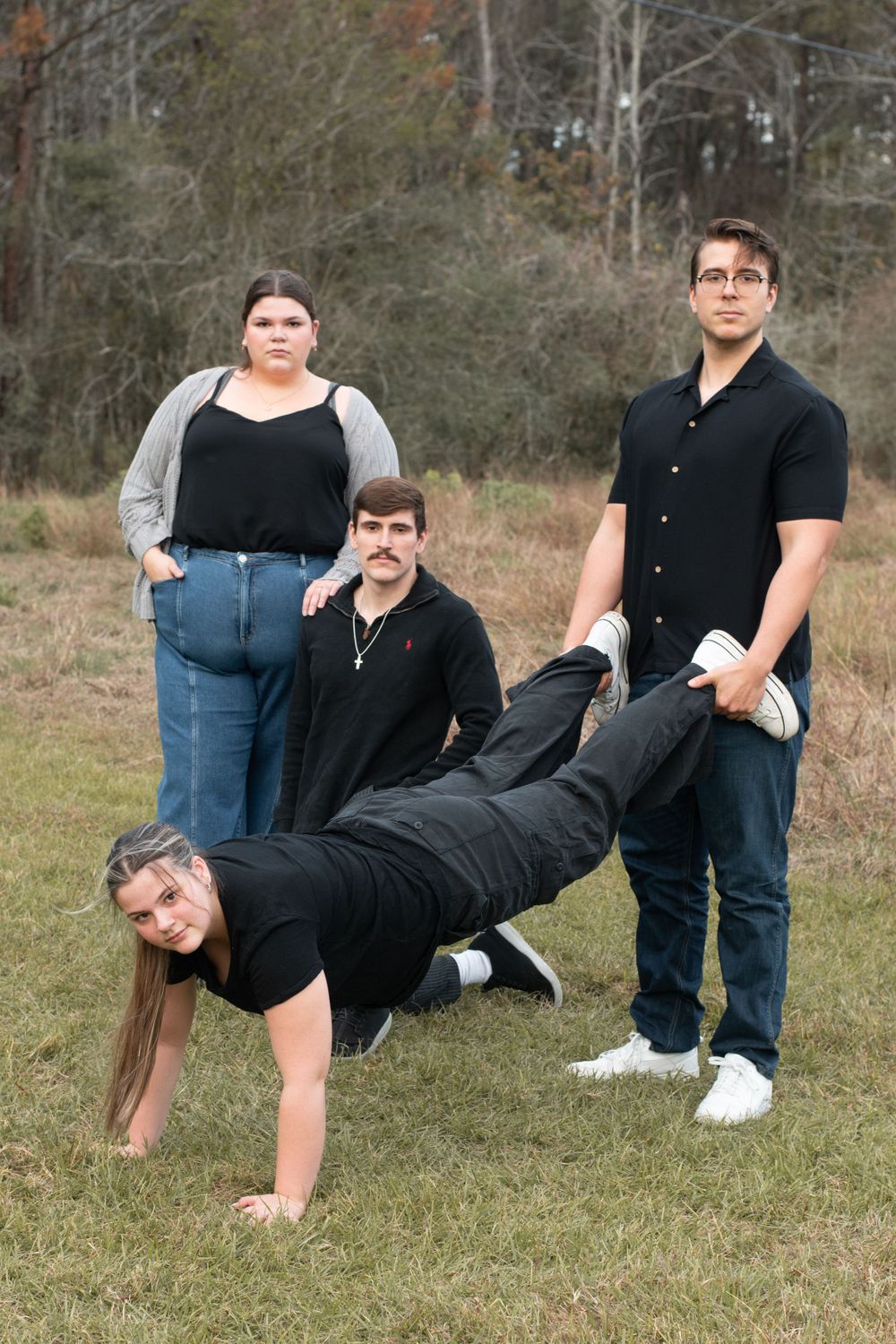 A playful group photo with one person doing a handstand while others watch in an outdoor setting.
