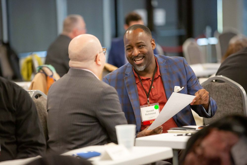 Business professionals engaged in animated discussion during networking event.