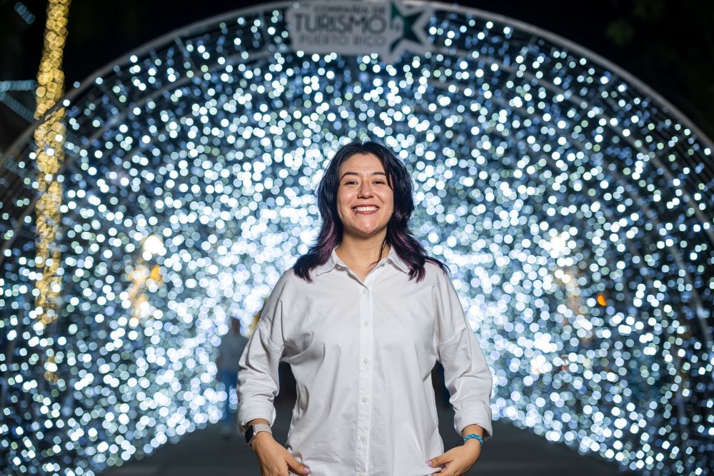 Playful nighttime portrait with bright blue and white bokeh light effects.