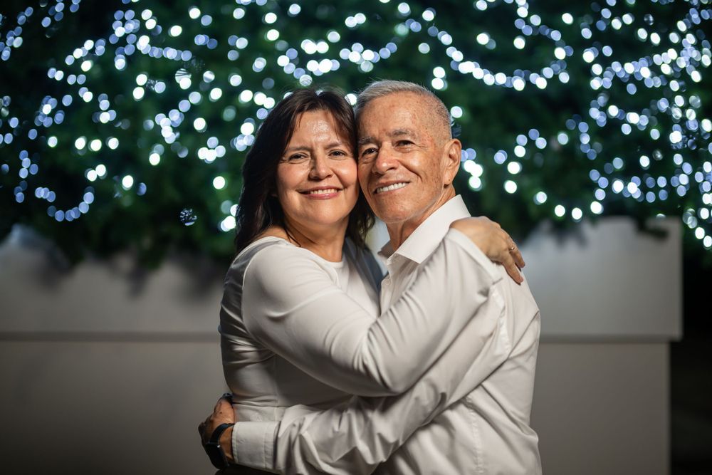 Joyful embrace captured against a backdrop of twinkling blue fairy lights.