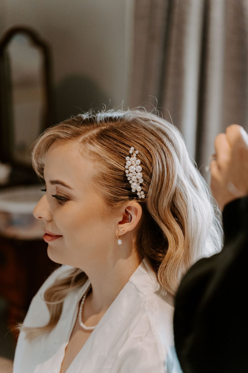 a close up of a bride pearl hair slide. the brides hair is in Hollywood waves.