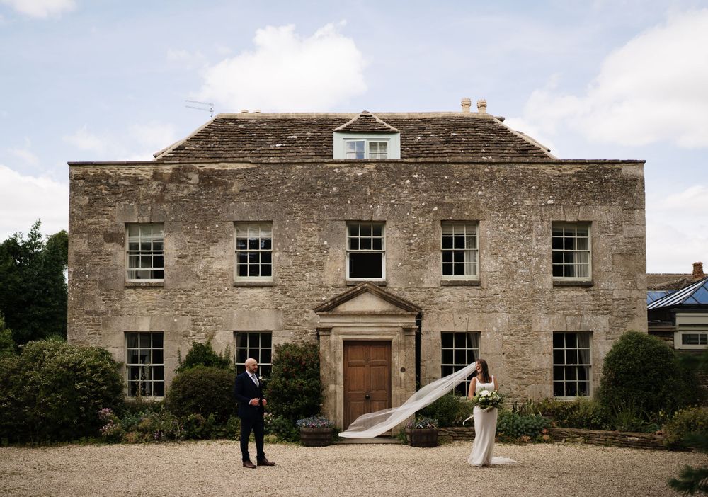 Elegant stone manor house with symmetrical windows and central doorway serving as a wedding venue.