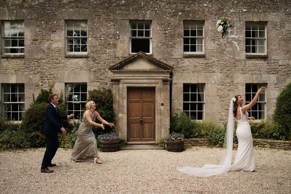 Wedding celebration scene outside a beautiful stone manor house with elegant architectural details.