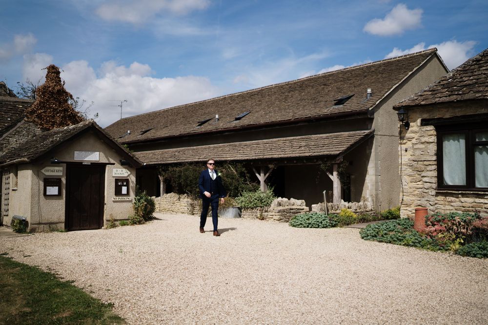 Rustic stone barn wedding venue with gravel driveway and landscaped gardens.
