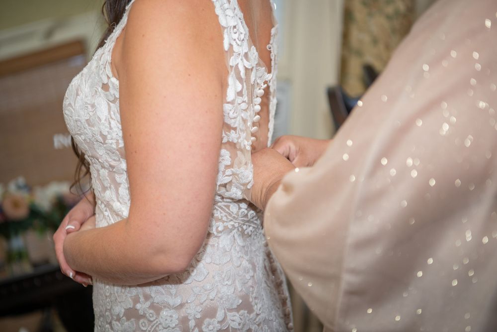 Close-up of delicate lace detailing on a white wedding dress bodice.
