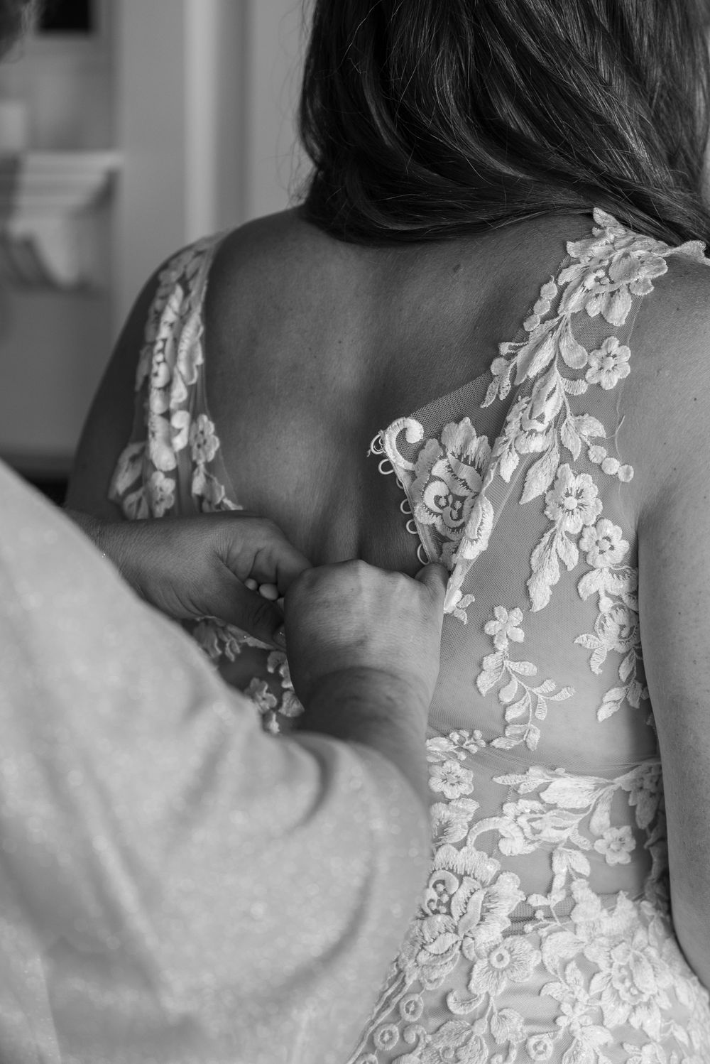 Monochrome close-up of wedding dress back details with delicate lace patterns.