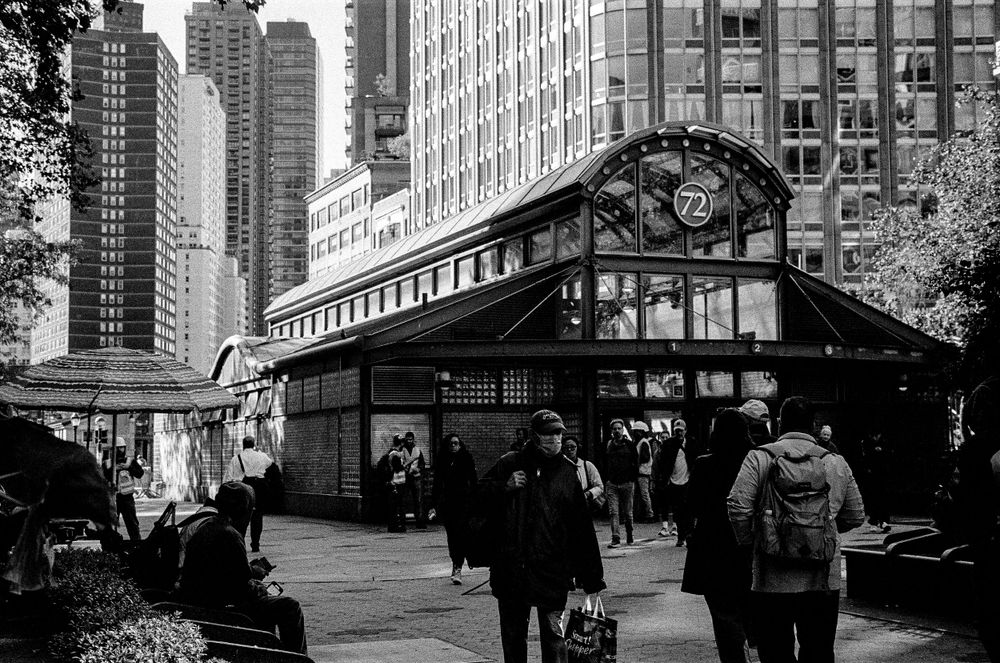Historic subway entrance kiosk with Art Nouveau design surrounded by modern skyscrapers.