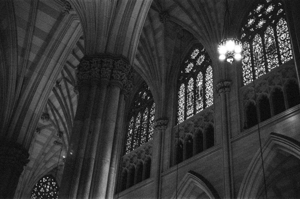 Gothic church interior with ornate stained glass windows and stone arches.