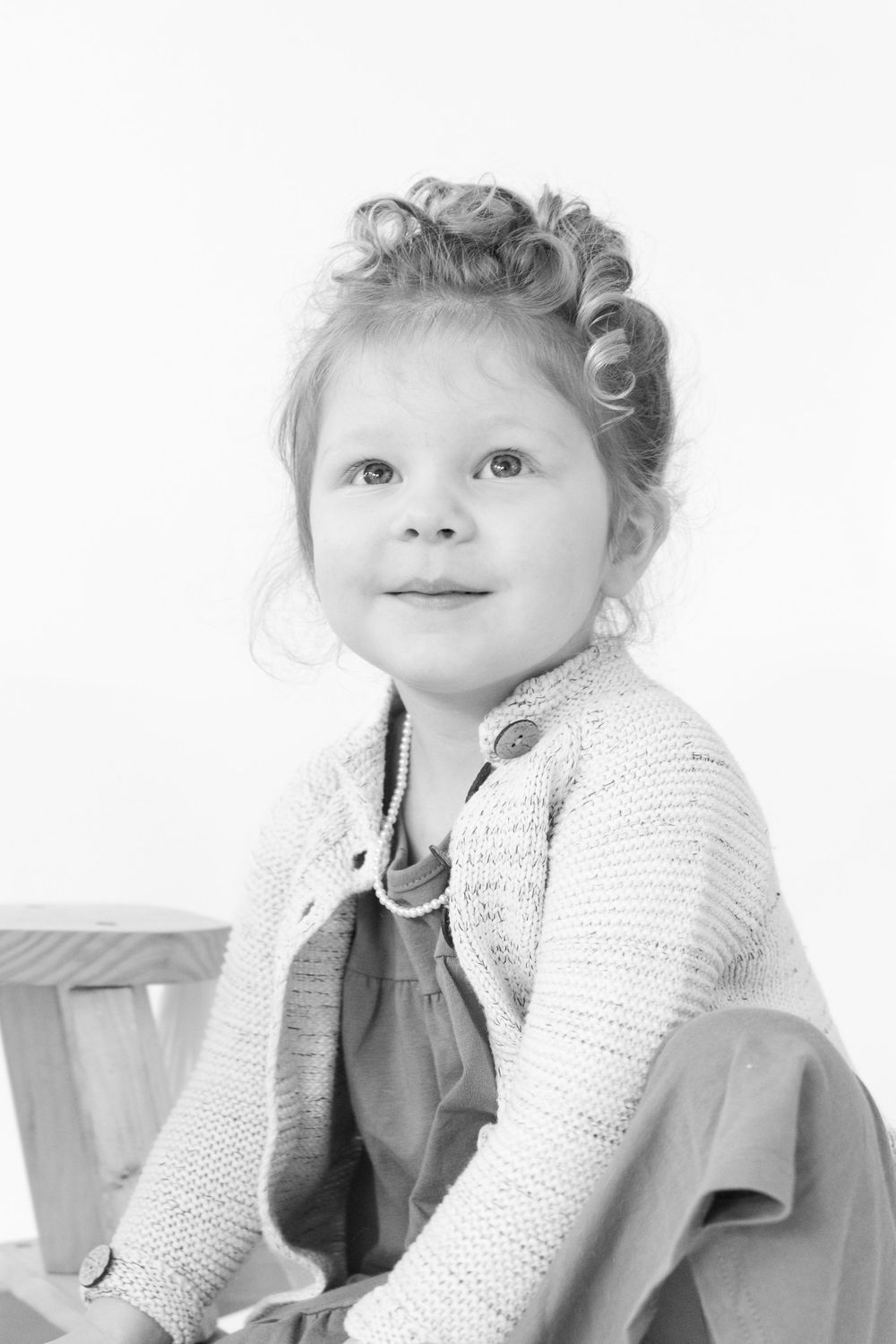 Portrait of young child wearing knit sweater in black and white photography.