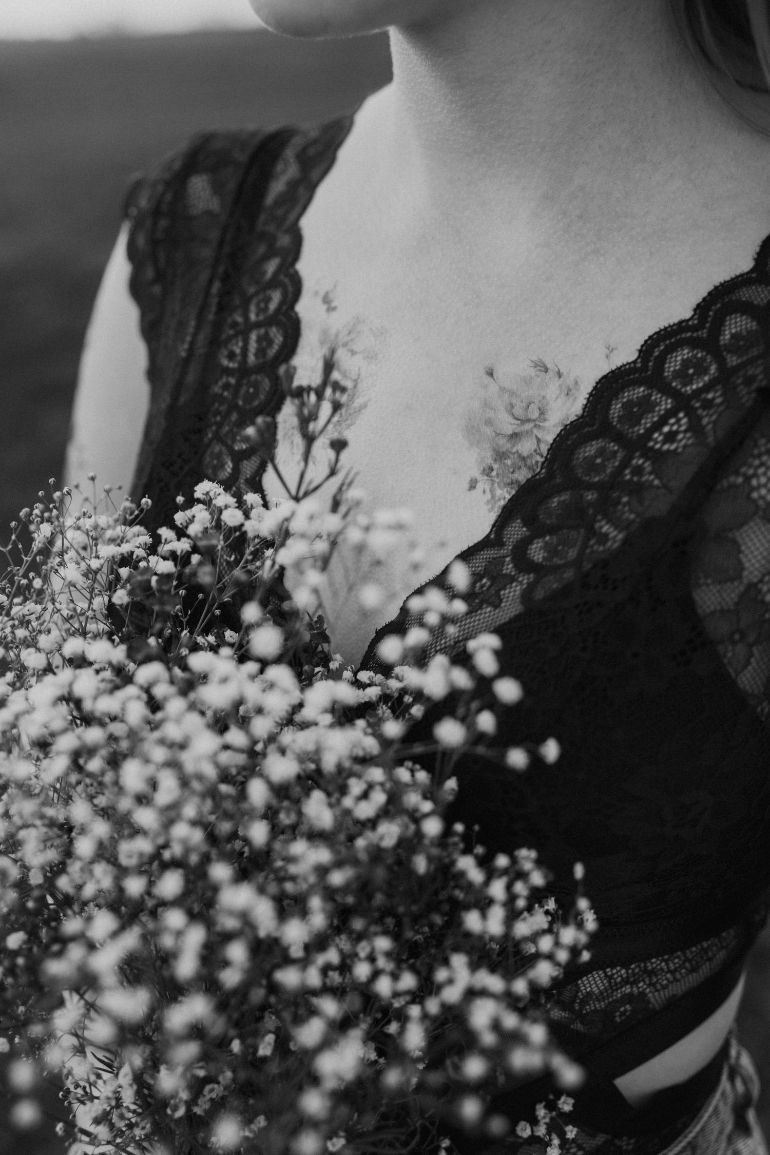 Close-up detail of black lace bodice with delicate baby's breath flowers.