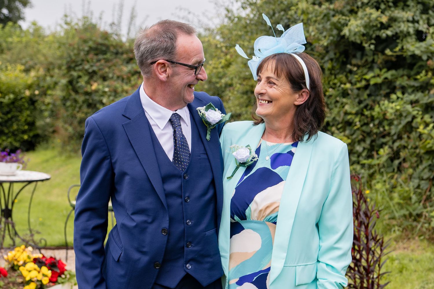 Wedding celebration in an outdoor garden setting with colorful flowers.