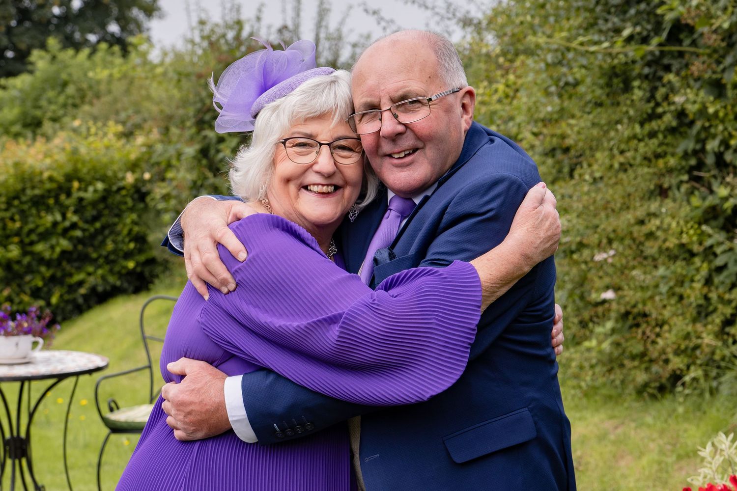 Outdoor wedding portraits showing couple embracing in a garden setting.