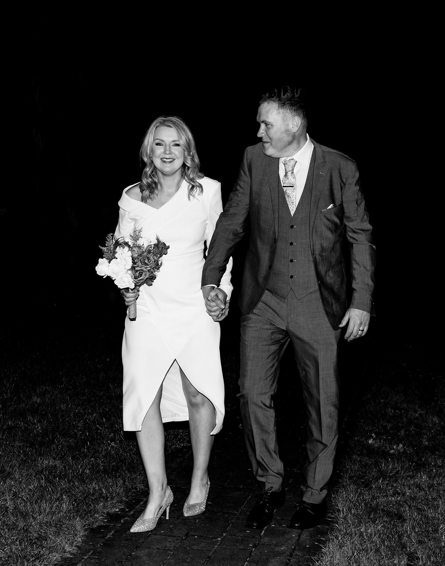 Black and white sequence showing couple's playful dance moves at night.