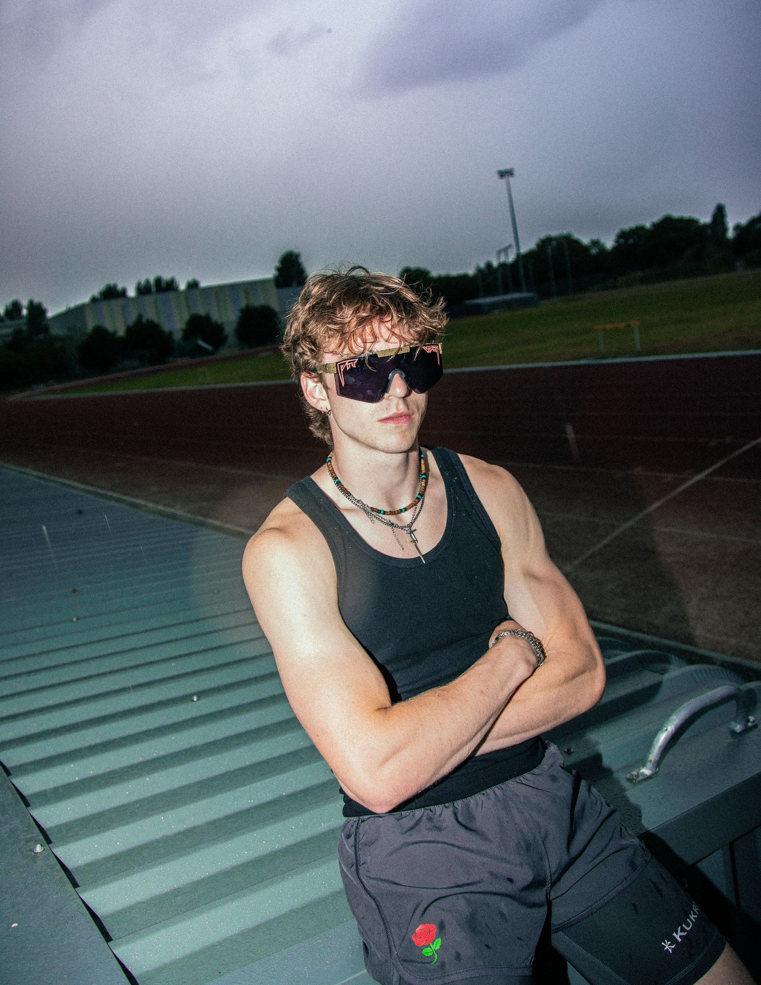 Athletic figure stretches and warms up on concrete steps against a cloudy sky.