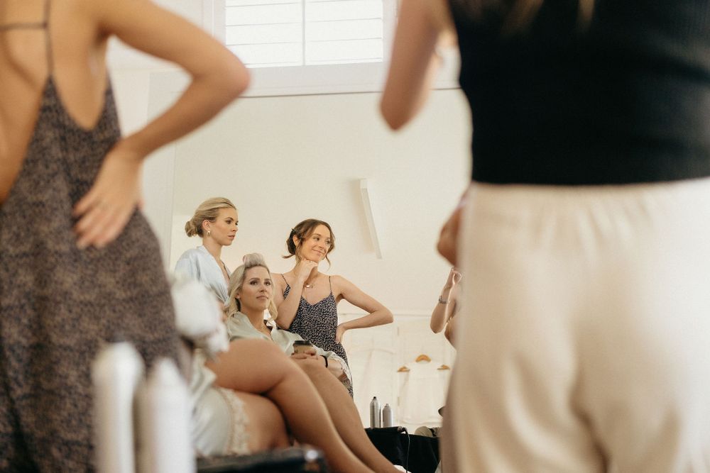 Dancers in leotards stretch and practice together in a bright dance studio during rehearsal.