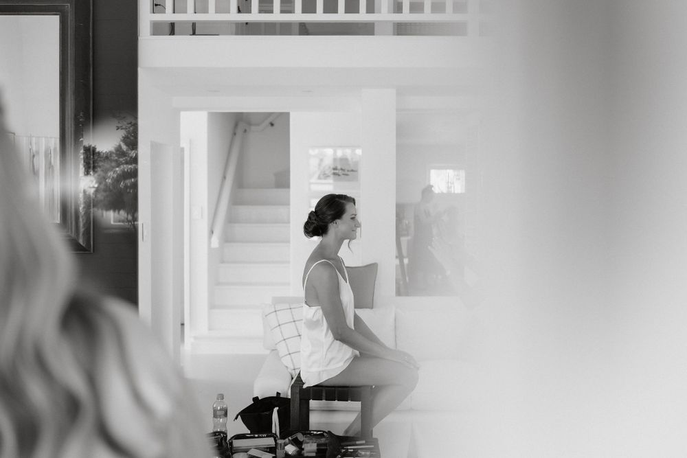 A bride sits in profile view during wedding preparations in a black and white photograph.