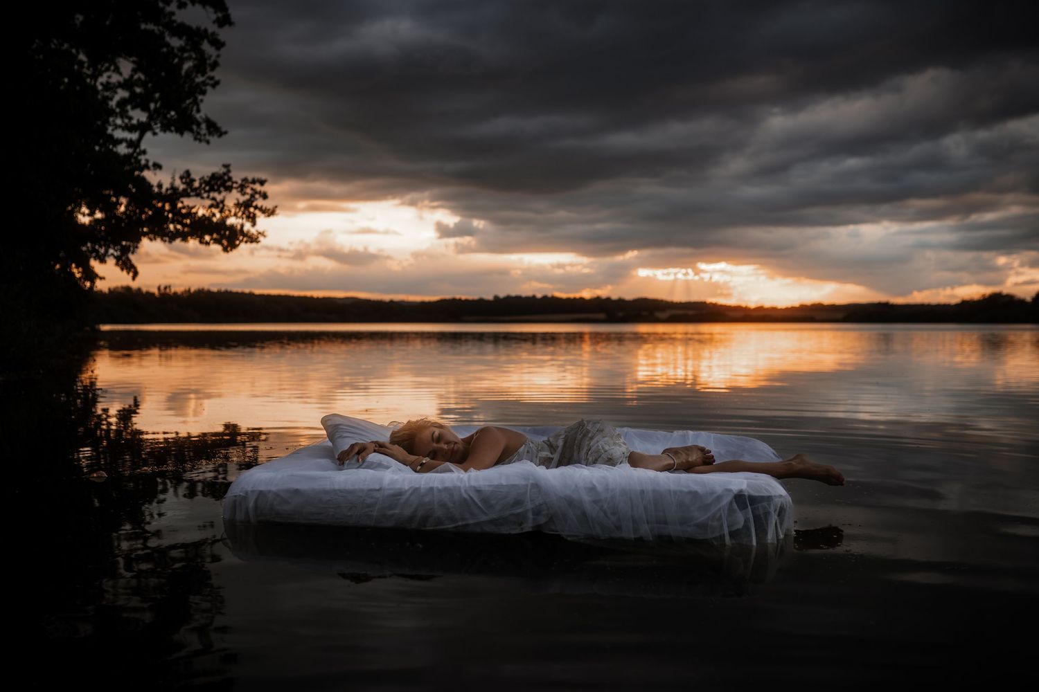 Boudoir foceni ve vode s modelkou lezici na matraci. Portret zachycujici krasu a pohodu pri zapadu slunce. Fotografka Pardubice, Jizni Cechy