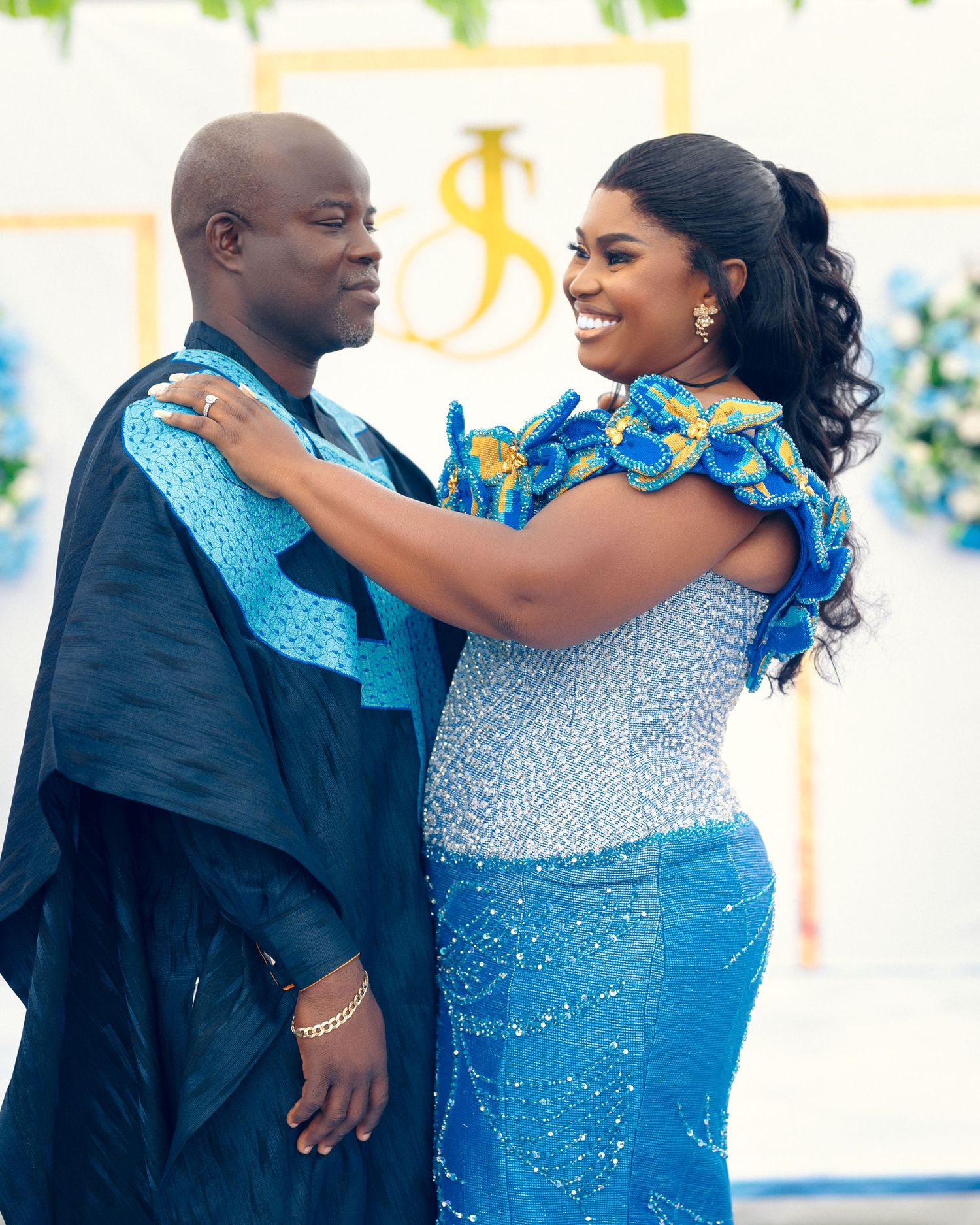 Romantic moment between couple in matching blue attire at an elegant wedding reception.