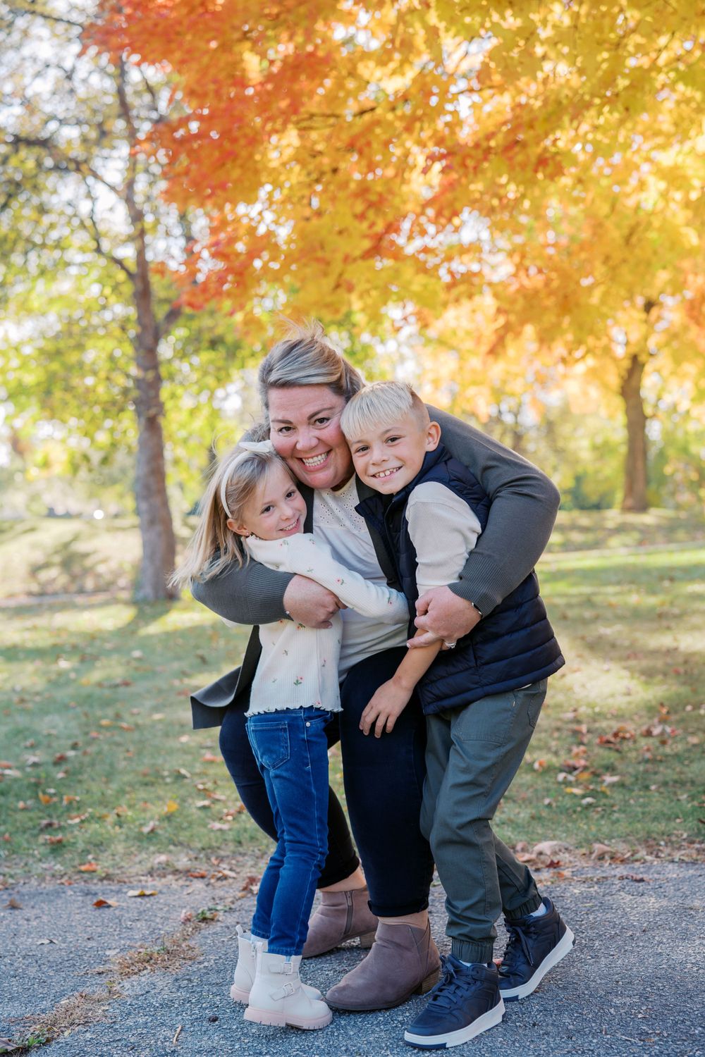 Candid family moment captured during an autumn photoshoot with warm golden lighting.