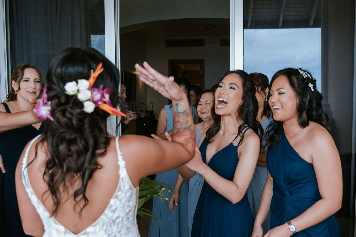 Wedding party celebrating with joyful reactions during first look reveal.