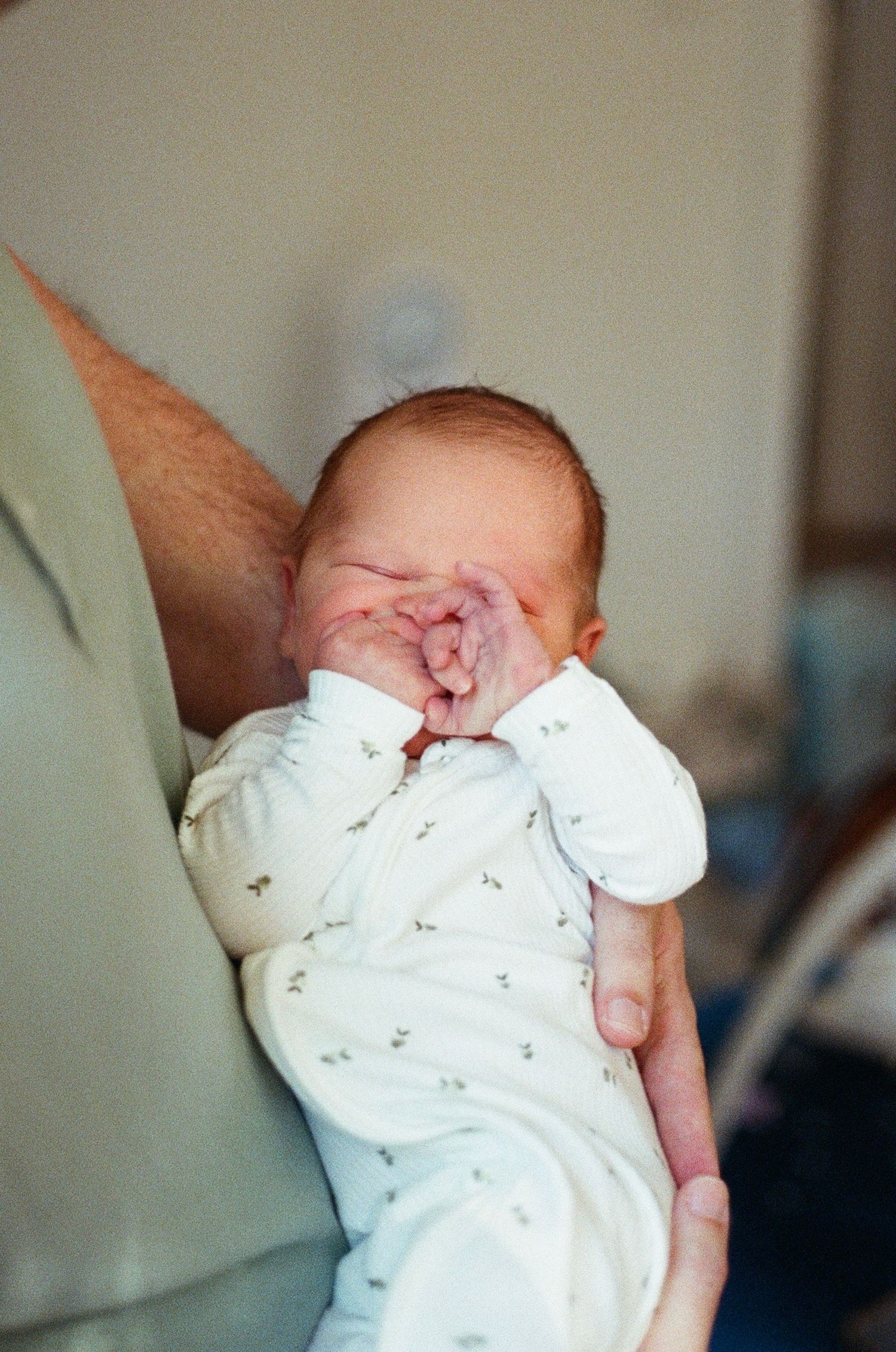 natural light newborn photography with parents and baby, soft film tones and emotional connection
