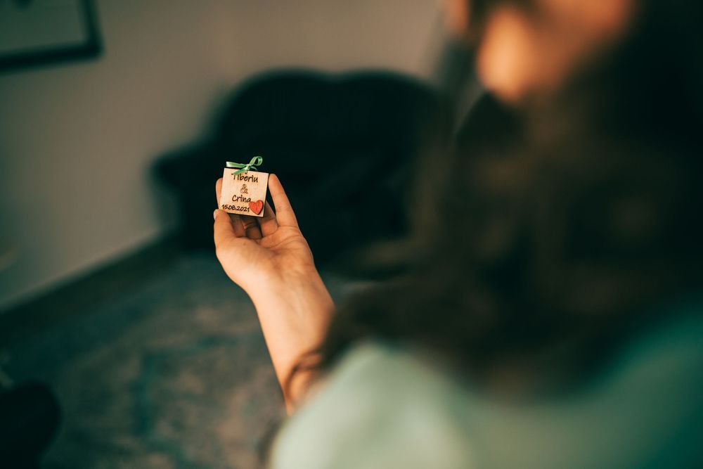 Bearded man holding a small decorative gift box indoors.