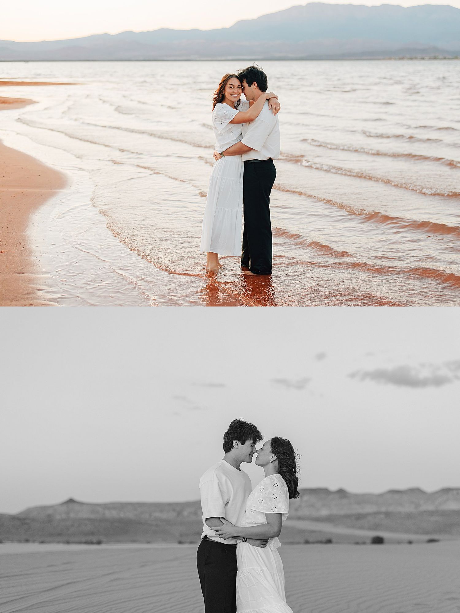 Couple embracing on a sandy beach at sunset in white outfits, with gentle waves and mountains in the background.