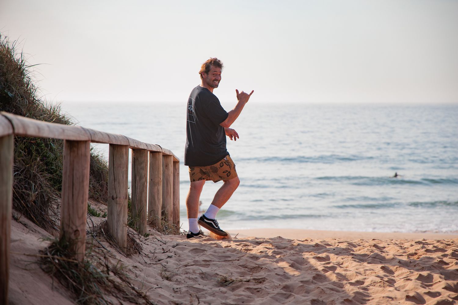 Butterbox Café owner Marty checking the surf and throwing a shaka — lifestyle brand photography, Northern Beaches Sydney