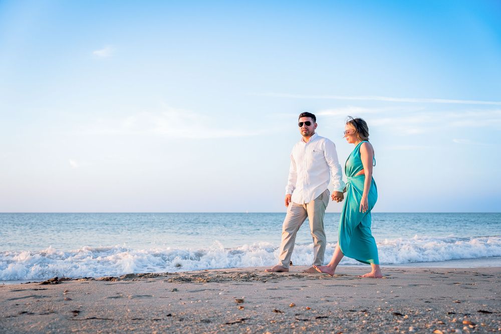 Pareja caminando por la arena en el Hotel Wayira Beach, capturados por fotógrafo de bodas profesional. Estética cinematográfica.