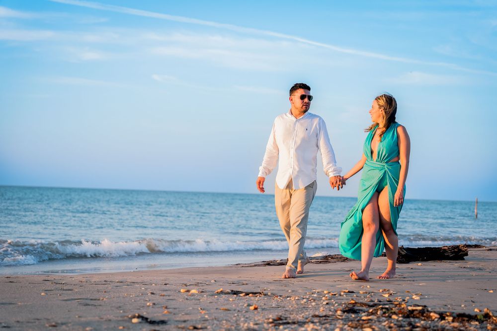 Pareja caminando por la arena en el Hotel Wayira Beach, capturados por fotógrafo de bodas profesional. Estética cinematográfica.