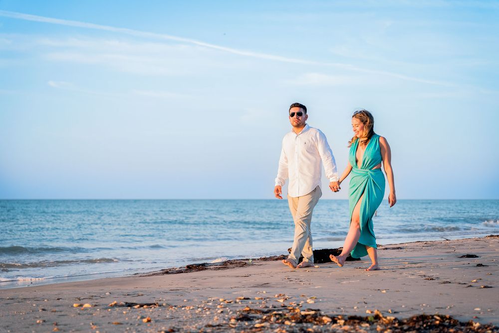 Pareja caminando por la arena en el Hotel Wayira Beach, capturados por fotógrafo de bodas profesional. Estética cinematográfica.