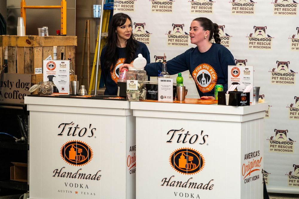Two women bartending at Tito's Handmade Vodka branded bar at a pet rescue charity event.