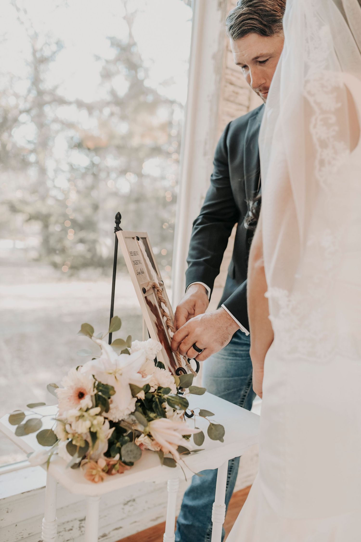 bride and groom braiding a knot of three strands on a cross
