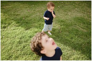 Punta Mita family photography session, two boys playing on green grass, candid outdoor lifestyle in natural light.