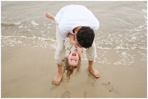 Couple beach moment in Puerto Vallarta, Puerto Vallarta family photographer lifestyle session, playful dip at ocean shoreline.
