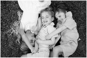 Black and white children laughing on grass in Riviera Nayarit, Riviera Nayarit family photographer candid lifestyle session outdoors.