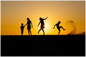 Sayulita family photographer, children playing at sunset silhouette, golden sky beach lifestyle moment.