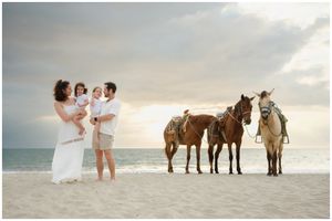 Punta Mita family photography session, family beach photos at sunset with horses, ocean waves, and candid moments.
