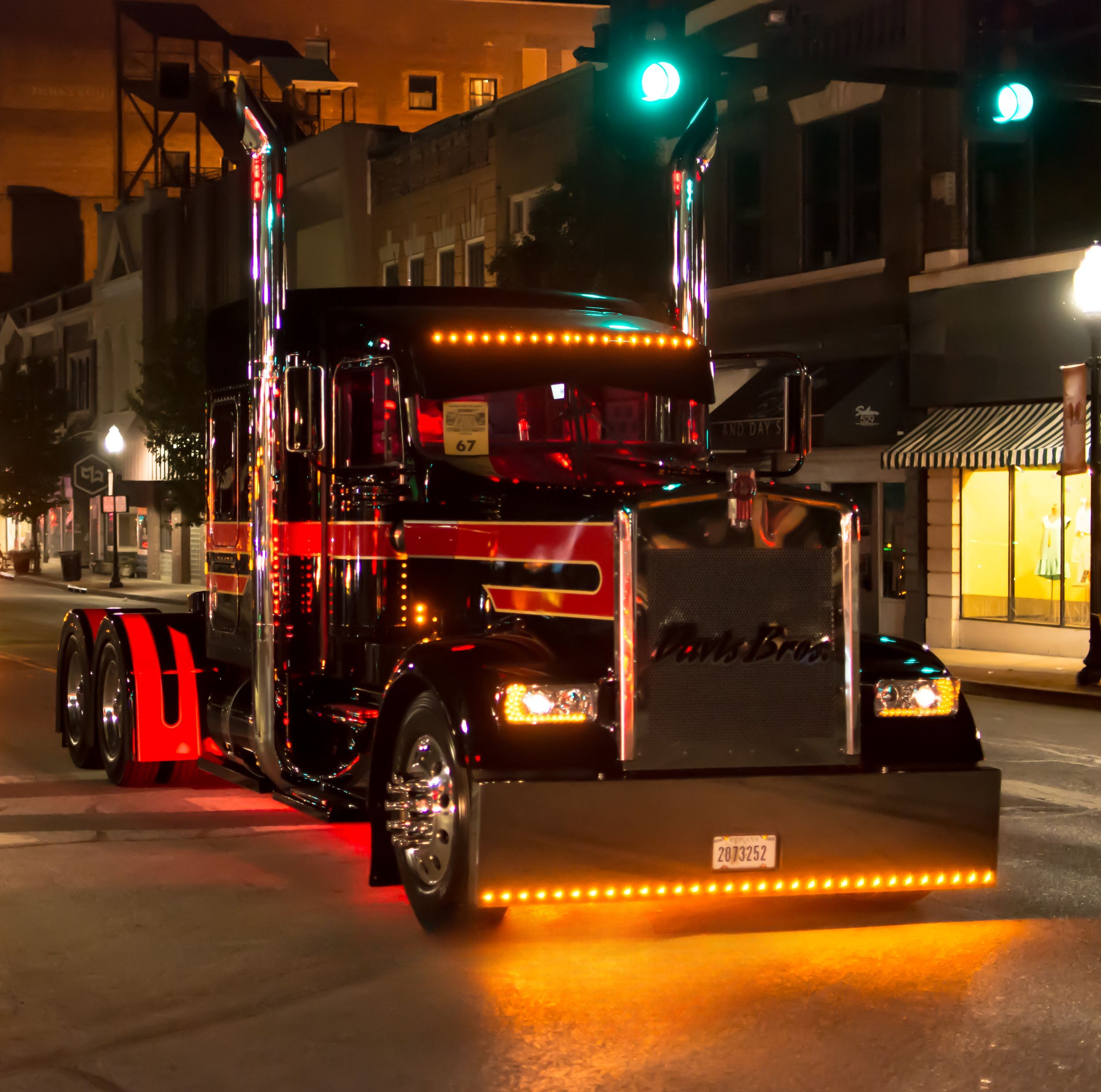 Black and red custom Peterbilt show truck with LED lights at night downtown Joplin, Missouri.