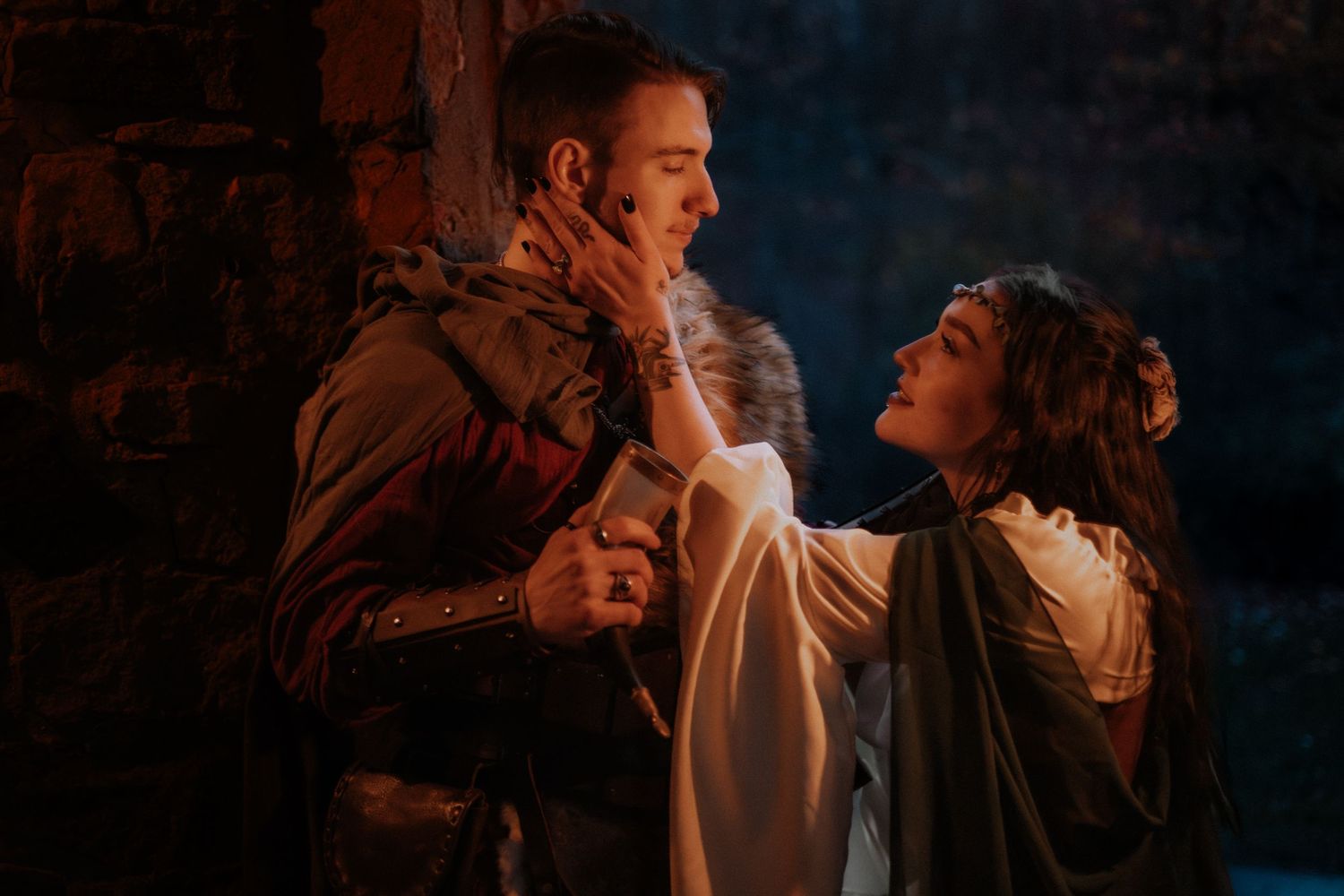 Dramatic medieval battle scene lit by warm firelight against dark background.