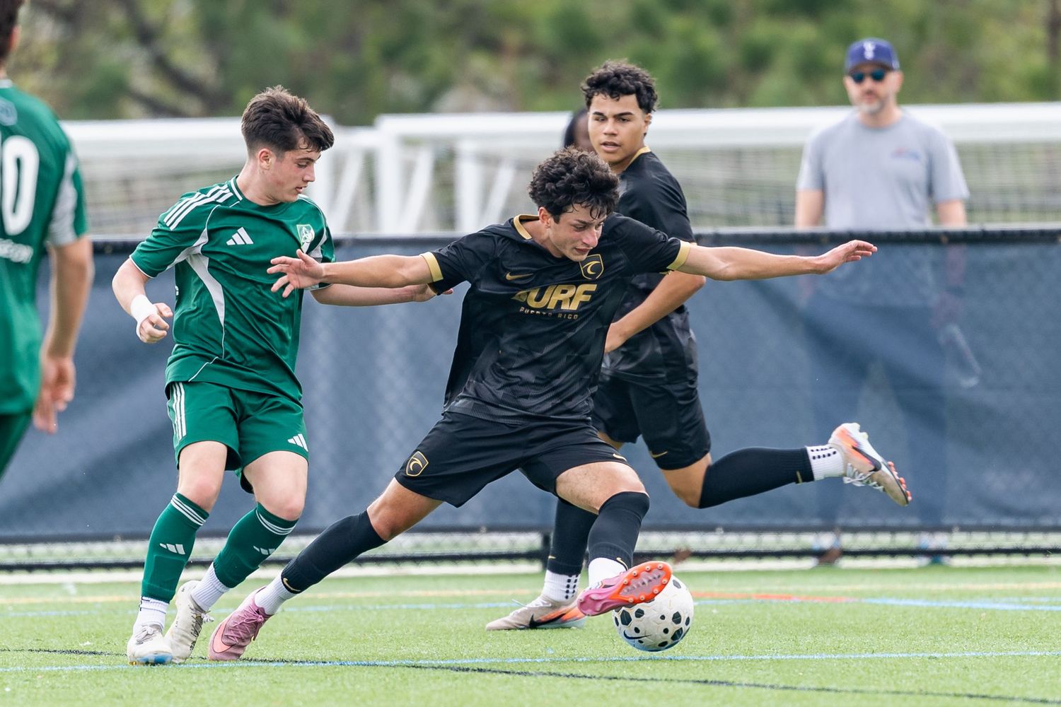 Soccer players compete for ball control during intense match on grass field.
