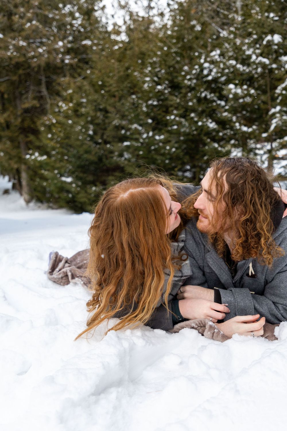 A couple rolling over each other in the snow